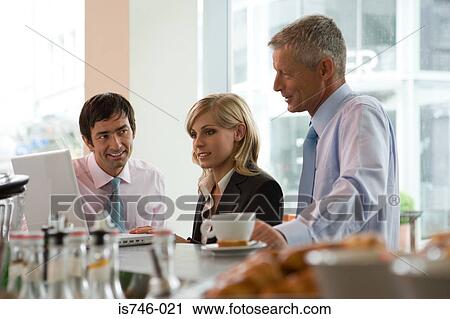 Stock Image - Business people having meeting at bar. Fotosearch