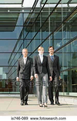 Business people walking along office building View Large Photo Image Stock Photo - Business people walking along office building. Fotosearch