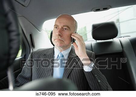 Businessman on phone sitting in car View Large Photo Image Stock Photography - Businessman on phone sitting in car. Fotosearch