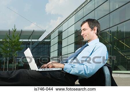 Businessman with laptop on office court View Large Photo Image Picture - Businessman with laptop on office court. Fotosearch
