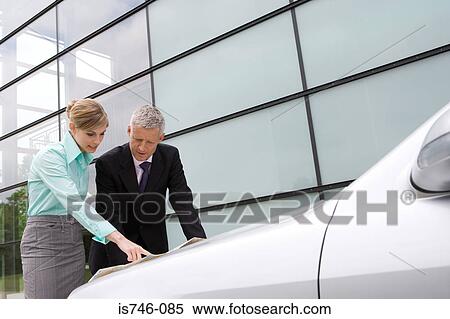 Businesswoman and businessman looking at map on automobile hood View Large Photo Image Stock Photography - Businesswoman and businessman looking at map on automobile hood. Fotosearch