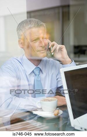Stock Photography - Man on phone in coffee bar. Fotosearch