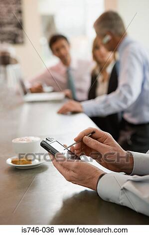 Stock Photograph - Man using handheld computer at bar counter . Fotosearch