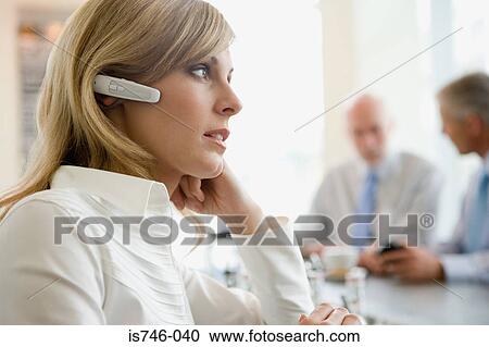 Woman wearing headset at bar counter View Large Photo Image Stock Image - Woman wearing headset at bar counter. Fotosearch