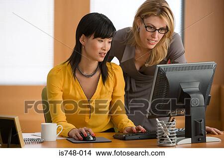 Picture - Two young women working on computer. Fotosearch