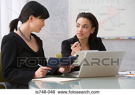 Two young women working with laptop View Large Photo Image Stock Photo - Two young women working with laptop. Fotosearch