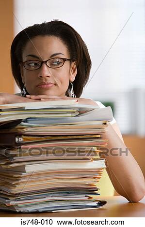 Young woman leaning on stack of files and paperwork View Large Photo Image Stock Image - Young woman leaning on stack of files and paperwork. Fotosearch