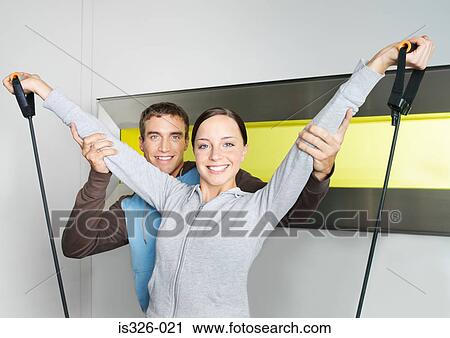 Instructor supporting woman weightlifting in health club View Large Photo Image Stock Image - Instructor supporting woman weightlifting in health club . Fotosearch