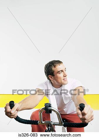 Man on exercise bike in health club View Large Photo Image Stock Image - Man on exercise bike in health club. Fotosearch