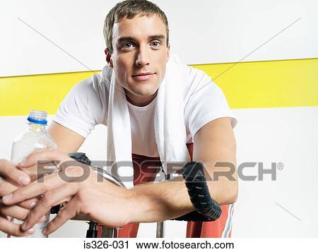 Man sitting on exercise bike View Large Photo Image Stock Image - Man sitting on exercise bike. Fotosearch