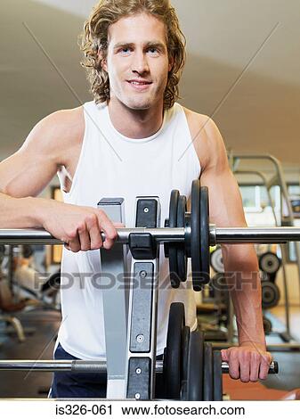Man standing at exercising equipment View Large Photo Image Stock Image - Man standing at exercising equipment . Fotosearch