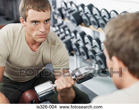 Picture - Man weightlifting in front of mirror. Fotosearch