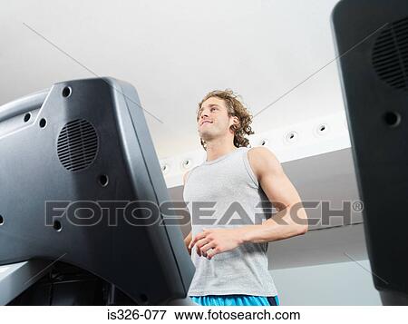 Mann on treadmill in health club View Large Photo Image Stock Photo - Mann on treadmill in health club . Fotosearch