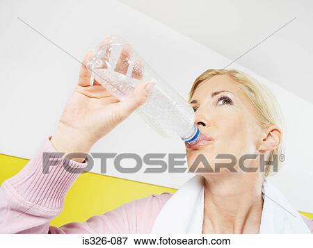 Woman drinking water in health club View Large Photo Image Stock Photo - Woman drinking water in health club . Fotosearch