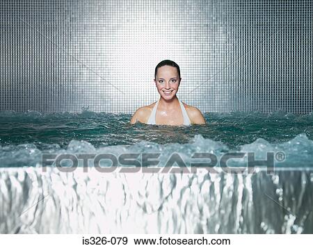 Stock Photo - Woman immersing in jacuzzi . Fotosearch
