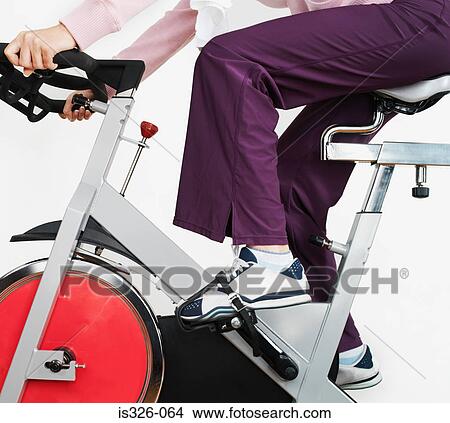 Woman on exercise bike in health club View Large Photo Image Picture - Woman on exercise bike in health club . Fotosearch