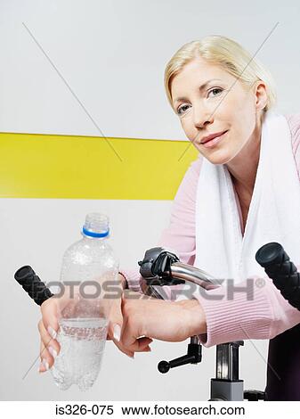 Woman on exercise bike in health club View Large Photo Image Stock Photography - Woman on exercise bike in health club . Fotosearch