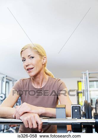 Woman standing at exercising equipment View Large Photo Image Stock Photo - Woman standing at exercising equipment . Fotosearch