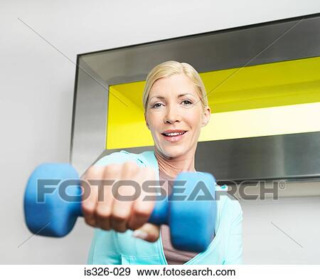 Stock Photo - Woman weightlifting in health club . Fotosearch