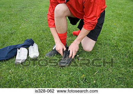 Footballer putting boots on View Large Photo Image Stock Image - Footballer putting boots on. Fotosearch