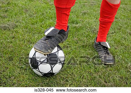 Footballer standing on football View Large Photo Image Stock Photography - Footballer standing on football. Fotosearch