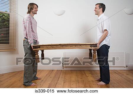 Stock Photography - Gay couple lifting table. Fotosearch