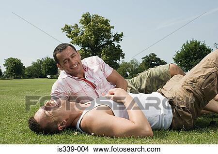 Gay couple sitting in park View Large Photo Image Picture - Gay couple sitting in park. Fotosearch