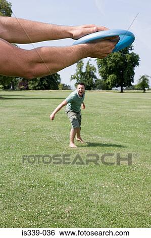Stock Photograph - Gay couple throwing flying disc. Fotosearch