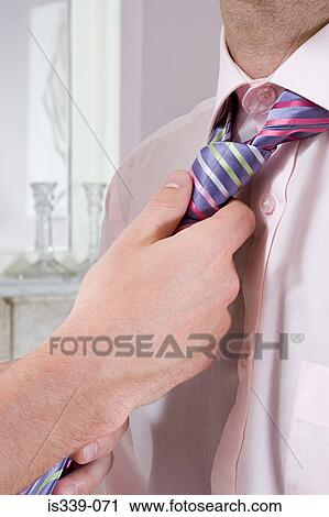 Stock Image - Man adjusting partners tie. Fotosearch
