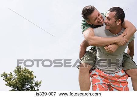 Man giving a boyfriend piggyback View Large Photo Image Stock Photo - Man giving a boyfriend piggyback. Fotosearch