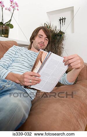 Stock Image - Man reading magazine. Fotosearch