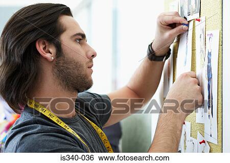Man pinning up fashion designs View Large Photo Image Stock Photograph - Man pinning up fashion designs. Fotosearch