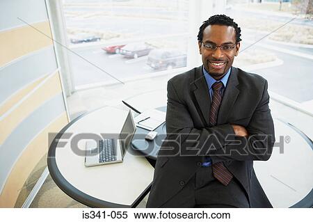 Businessman sitting on his desk View Large Photo Image Stock Photography - Businessman sitting on his desk. Fotosearch