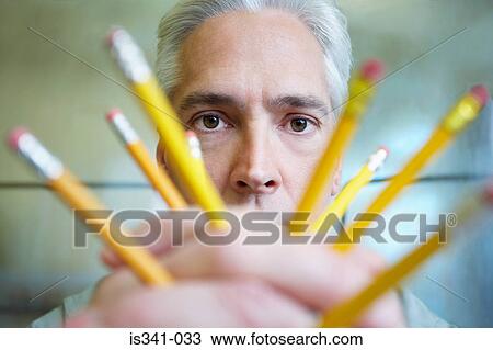 Stock Image - Man holding pencils. Fotosearch