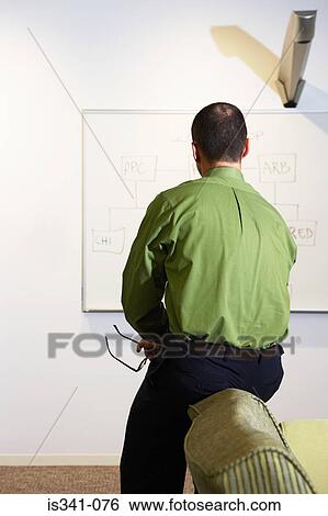 Stock Photograph - Office worker looking at whiteboard. Fotosearch