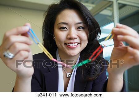 Stock Image - Woman holding paperclips. Fotosearch