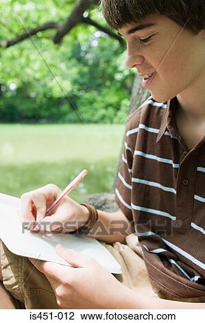 Boy writing in a notebook View Large Photo Image Stock Image - Boy writing in a notebook. Fotosearch