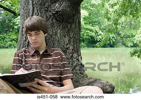 Boy writing in a notebook View Large Photo Image Stock Photo - Boy writing in a notebook. Fotosearch