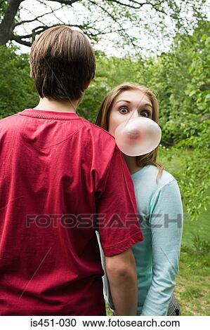 Stock Image - Girl blowing a bubble gum bubble. Fotosearch