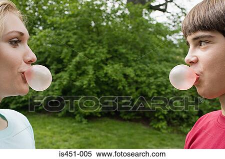 Teenage couple blowing bubble gum bubbles View Large Photo Image Stock Photography - Teenage couple blowing bubble gum bubbles. Fotosearch