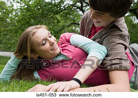 Teenage couple relaxing in a park View Large Photo Image Stock Image - Teenage couple relaxing in a park. Fotosearch
