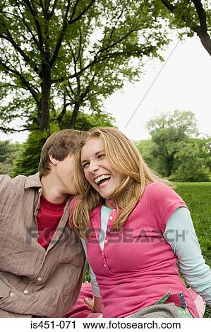 Stock Image - Teenage couple relaxing in a park. Fotosearch