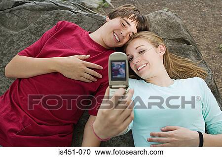 Teenage couple using a camera telephone View Large Photo Image Stock Image - Teenage couple using a camera telephone. Fotosearch