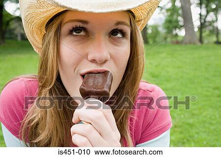 Stock Image - Teenage girl eating ice cream. Fotosearch