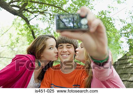 Stock Photography - Teenagers posing for photographs. Fotosearch