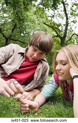 Stock Image - Teenagers relaxing in a park. Fotosearch
