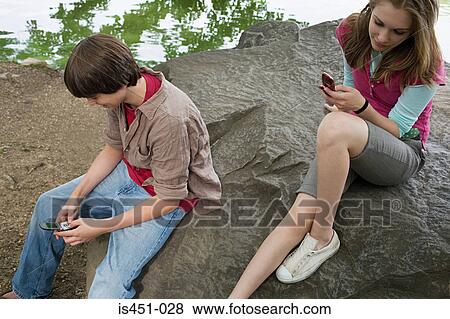 Stock Photo - Teenagers using cellular telephones. Fotosearch