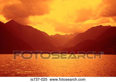 Mountains and water glowing in sunset View Large Photo Image Stock Photography - Mountains and water glowing in sunset. Fotosearch