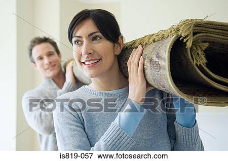Couple carrying a rug View Large Photo Image Stock Photo - Couple carrying a rug. Fotosearch