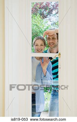 Couple looking through window View Large Photo Image Stock Image - Couple looking through window. Fotosearch